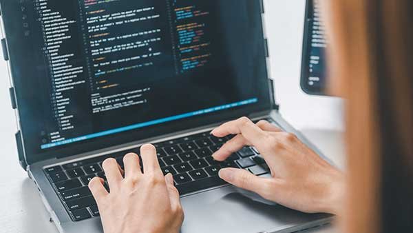 Hands of a woman typing code
